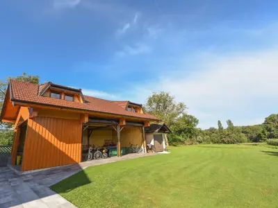 a house with a garage and a grass yard at Cozy Luxe Holiday Home with Natural Thermal Bath - Seven Bedroom Holiday Home in Cerklje ob Krki