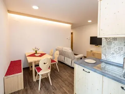a kitchen and living room with a table and a couch at The Woodland Nook Apartments Bohinj - Two Bedroom Apartment with Balcony in Bohinj