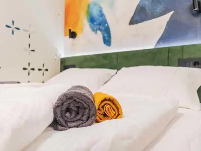 a bed with two white pillows and a blanket at Bovec Chic Apartment with Sauna - One Bedroom Apartment with Balcony in Bovec