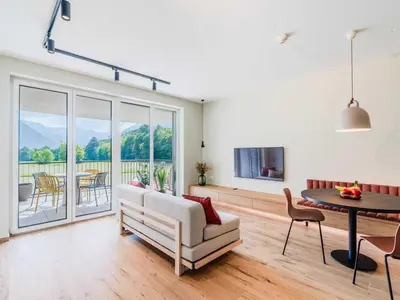 a living room with a couch and a table and a tv at Bovec Chic Apartment with Sauna - One Bedroom Apartment with Balcony in Bovec