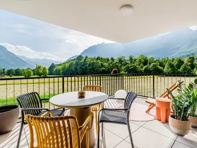 a balcony with a table and chairs and mountains at Bovec Chic Apartment with Sauna - One Bedroom Apartment with Balcony in Bovec