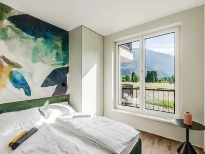 a bedroom with a bed and a large window at Bovec Chic Apartment with Sauna - One Bedroom Apartment with Balcony in Bovec