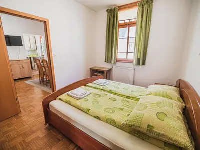 a bedroom with a bed with a green comforter at Bovec Picturesque Mountain Vista Residences - One Bedroom Apartment in Bovec