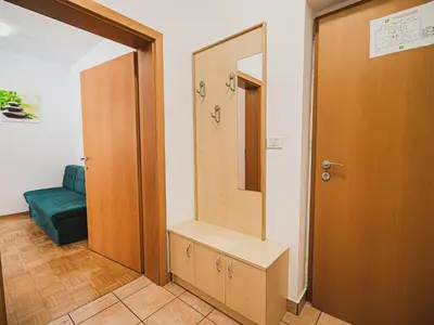 a bathroom with a sink and a mirror and a door at Bovec Picturesque Mountain Vista Residences - One Bedroom Apartment in Bovec