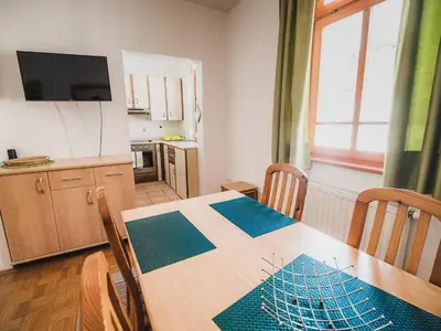 a dining room with a table and a kitchen at Bovec Picturesque Mountain Vista Residences - One Bedroom Apartment in Bovec