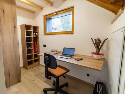 a tiny house office with a desk and a laptop at Elegant Warm Bliss Hideaway Escape Lodge - Holiday Home with Hot-Tub and Sauna in Šenčur
