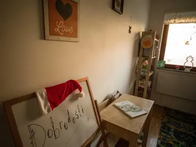 a room with a table and a chair with a sign at Rustic Refuge Glamping with Hot-Tub and Sauna - Two Bedroom Apartment with Terrace in Zreče