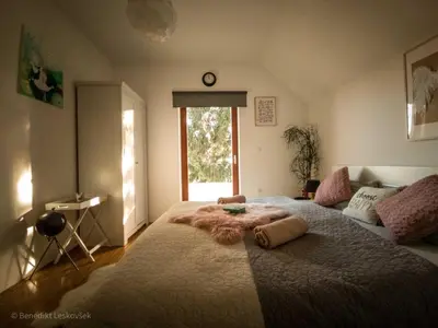 a bedroom with a large bed with a blanket on it at Rustic Refuge Glamping with Hot-Tub and Sauna - Two Bedroom Apartment with Terrace in Zreče