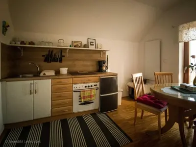 a kitchen with a stove and a dining room table at Rustic Refuge Glamping with Hot-Tub and Sauna - Two Bedroom Apartment with Terrace in Zreče