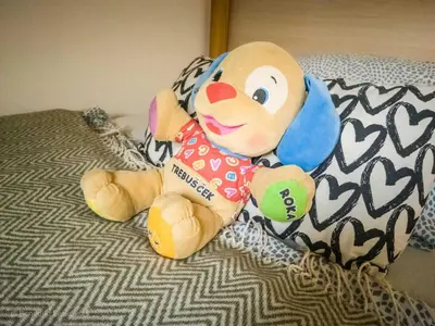 a stuffed teddy bear sitting on a bed at Rustic Refuge Glamping with Hot-Tub and Sauna - Two Bedroom Apartment with Terrace in Zreče