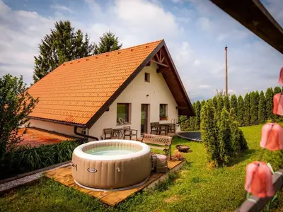 a house with a large hot tub in the yard at Rustic Refuge Glamping with Hot-Tub and Sauna - Two Bedroom Apartment with Terrace in Zreče