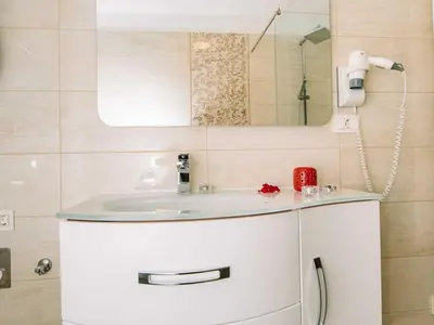 a bathroom with a white sink and a mirror at Bled Prestigious and Stylish Apartments - Standard One Bedroom Apartment with Balcony in Bled