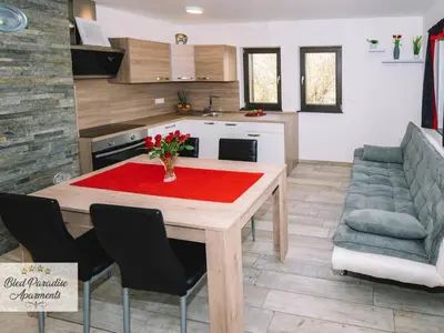 a kitchen and dining room with a table and a couch at Bled Prestigious and Stylish Apartments - Standard One Bedroom Apartment with Balcony in Bled