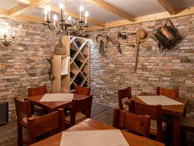 a restaurant with tables and chairs and a brick wall at Echo Valley Hillside Holiday Home with Sauna - Two Bedroom Holiday Home with Sauna in Ribnica