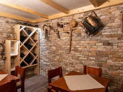 a dining room with a brick wall and wooden tables and chairs at Echo Valley Hillside Holiday Home with Sauna - Two Bedroom Holiday Home with Sauna in Ribnica