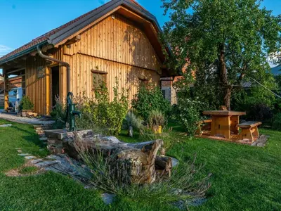 a log cabin with a garden in front of it at Echo Valley Hillside Holiday Home with Sauna - Two Bedroom Holiday Home with Sauna in Ribnica