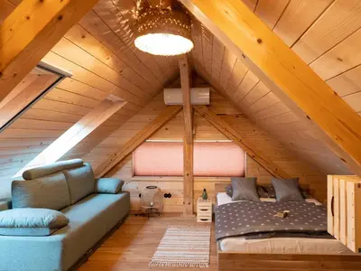 a room with a couch and a bed in a attic at Echo Valley Hillside Holiday Home with Sauna - Two Bedroom Holiday Home with Sauna in Ribnica