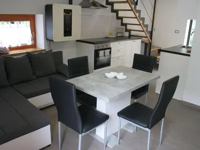 a kitchen and living room with a table and chairs at Riverside Rustic Ridge Apartments with Balcony - Two Bedroom Apartment with Balcony in Slappe dʼIdria