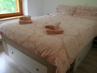 a bed with two towels on top of it at Riverside Rustic Ridge Apartments with Balcony - Two Bedroom Apartment with Balcony in Slappe dʼIdria
