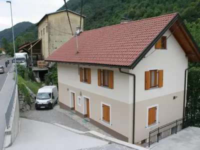 a white house with a red roof and a car at Riverside Rustic Ridge Apartments with Balcony - Two Bedroom Apartment with Balcony in Slappe dʼIdria
