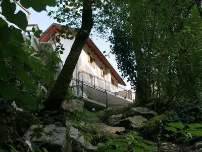 a building in the middle of a forest at Riverside Rustic Ridge Apartments with Balcony - Two Bedroom Apartment with Balcony in Slappe dʼIdria