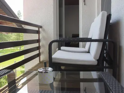 a white chair sitting on a porch with a glass table at Two Bedroom Apartment in Rečica ob Savinji