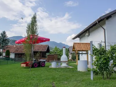 a yard with a picnic table and a red umbrella at Two Bedroom Apartment in Rečica ob Savinji