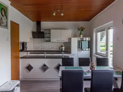 a kitchen with a table and some chairs in a room at Two Bedroom Apartment in Rečica ob Savinji