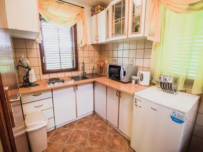 a small kitchen with white cabinets and a microwave at Harvest Horizon Holiday Home with Sauna - One Bedroom Holiday Home in Brežice
