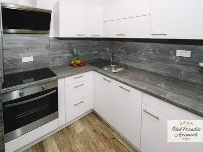 a kitchen with white cabinets and a sink at Bled Prestigious and Stylish Apartments - Classic Studio Apartment with Terrace in Bled
