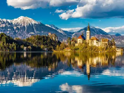 a church on an island in the middle of a lake at Bled Prestigious and Stylish Apartments - Classic Studio Apartment with Terrace in Bled