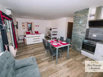 a kitchen and living room with a table and chairs at Bled Prestigious and Stylish Apartments - Classic Studio Apartment with Terrace in Bled