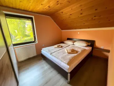 a bed in a small room with a window at Two Bedroom Apartment with Balcony and Mountain View in Preddvor