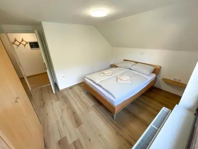 a small bedroom with a bed and wooden floors at Two Bedroom Apartment with Balcony and Mountain View in Preddvor