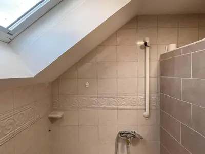 a bathroom with a sloped ceiling and a shower at Two Bedroom Apartment with Balcony and Mountain View in Preddvor