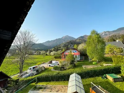 a view of a farm with a red barn and vehicles at Two Bedroom Apartment with Balcony and Mountain View in Preddvor
