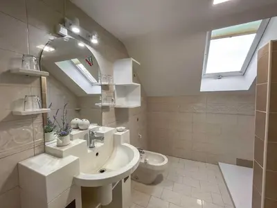 a bathroom with a sink and a toilet and a window at Two Bedroom Apartment with Balcony and Mountain View in Preddvor