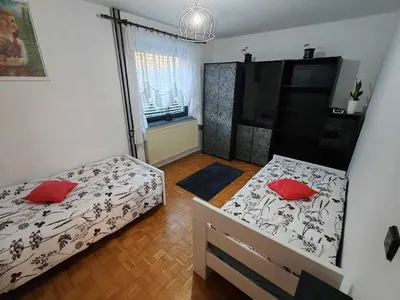 a bedroom with two beds with red pillows at Brezovica Spacious Family-Friendy Apartment - Two Bedroom Apartment with Balcony in Smarjeske Toplice