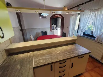 a kitchen with a counter with a bed in the background at Brezovica Spacious Family-Friendy Apartment - Two Bedroom Apartment with Balcony in Smarjeske Toplice