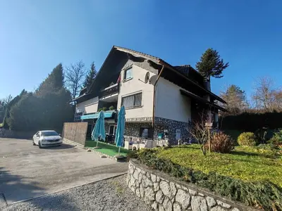 a house with a car parked in front of it at Brezovica Spacious Family-Friendy Apartment - Two Bedroom Apartment with Balcony in Smarjeske Toplice
