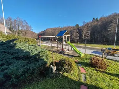 a park with a playground with a green slide at Brezovica Spacious Family-Friendy Apartment - Two Bedroom Apartment with Balcony in Smarjeske Toplice