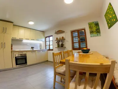 a kitchen and dining room with a wooden table and chairs at Hillside Haven Holiday Home with Sauna and Hot-Tub - One Bedroom Holiday Home with Sauna and Hot-Tub in Podbočje