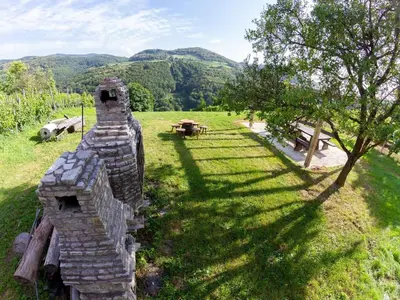 an old stone house with a picnic table in a field at Hillside Haven Holiday Home with Sauna and Hot-Tub - One Bedroom Holiday Home with Sauna and Hot-Tub in Podbočje