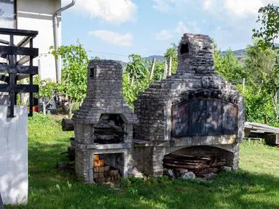 an old stone oven sitting in the grass at Hillside Haven Holiday Home with Sauna and Hot-Tub - One Bedroom Holiday Home with Sauna and Hot-Tub in Podbočje