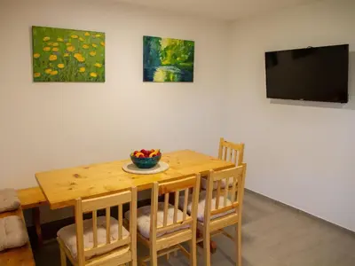a dining room with a table and a tv at Hillside Haven Holiday Home with Sauna and Hot-Tub - One Bedroom Holiday Home with Sauna and Hot-Tub in Podbočje