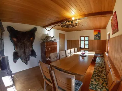 a dining room with a large wooden table and chairs at Hillside Haven Holiday Home with Sauna and Hot-Tub - One Bedroom Holiday Home with Sauna and Hot-Tub in Podbočje