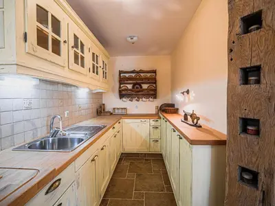 a kitchen with wooden cabinets and a sink at Hidden Authentic Haven Apartments - One Bedroom Apartment with Terrace in Sevnica