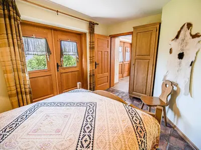 a bedroom with a bed and a chair and windows at Hidden Authentic Haven Apartments - One Bedroom Apartment with Terrace in Sevnica