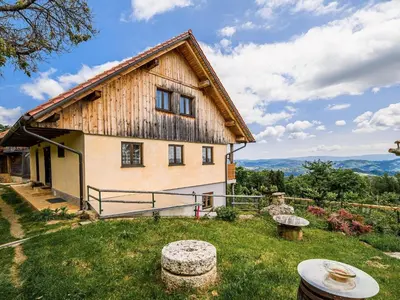 a large wooden house with mountains in the background at Hidden Authentic Haven Apartments - One Bedroom Apartment with Terrace in Sevnica