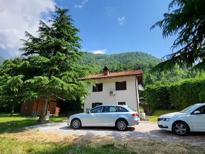 two cars parked in front of a house at Peaceful Countryside Holiday Home with Terrace - One Bedroom Holiday Home with Terrace in Tolmin